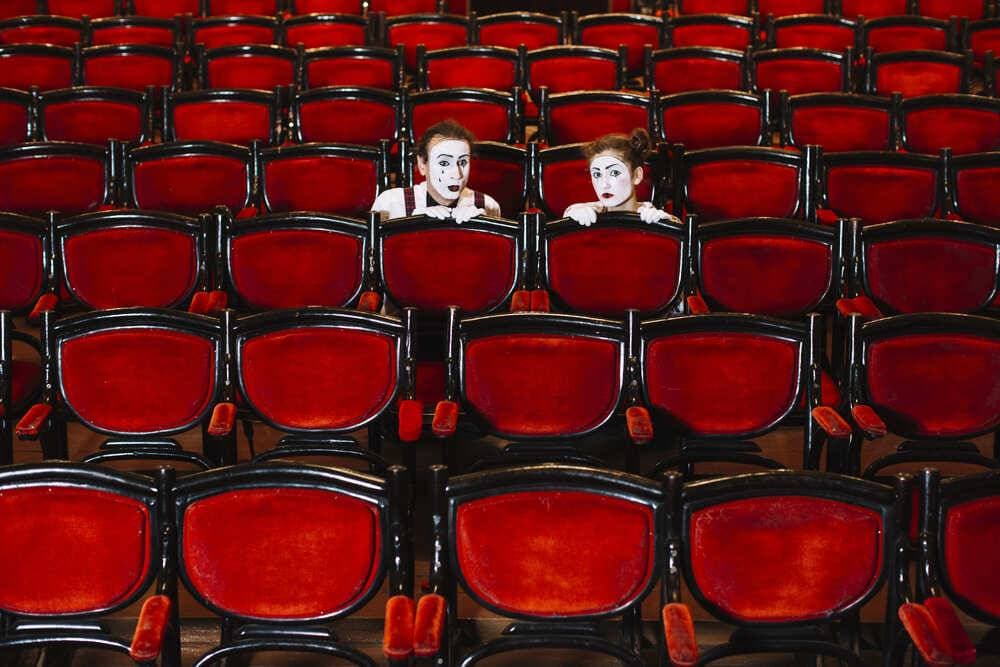 artiste-mime-homme-femme-cachant-rangée-fauteuils