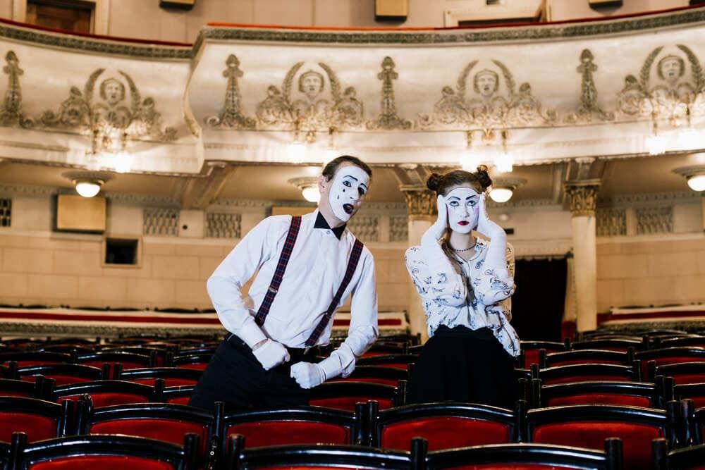 mime-homme-posant-près-d'une-chaise-triste-mime-femme-assise
